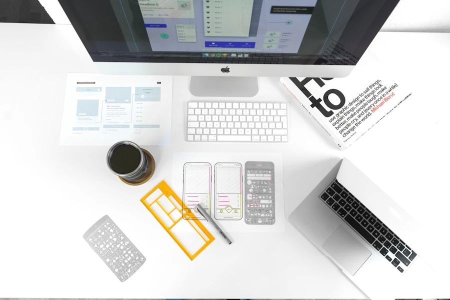 App screen wireframes sketched on paper beside a phone and pencil