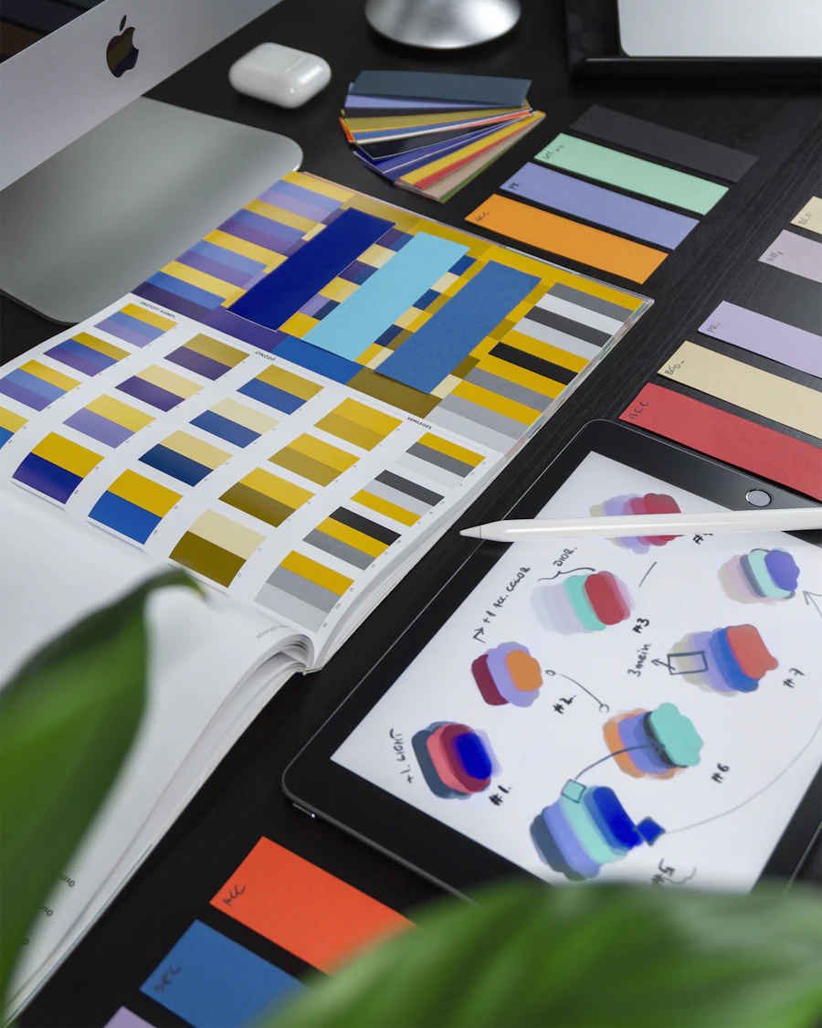 Brand color swatches and style guide pages spread across a designer desk
